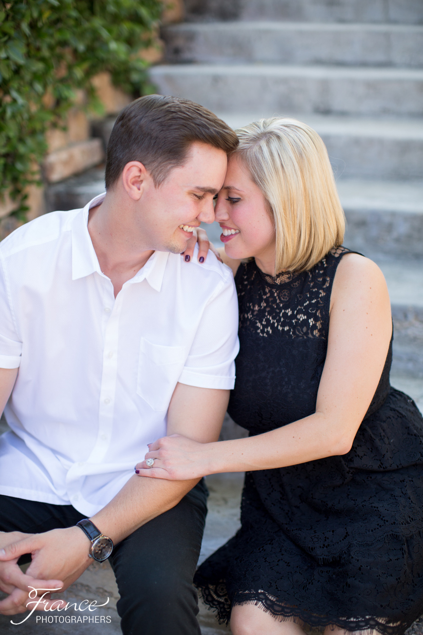 Engaged couple sitting on stairs with loving gaze into each others' eyes